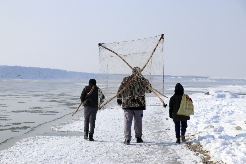 Ağrı’da dondurucu soğuğa rağmen nehirdeki buzları kırıp balık avlıyorlar