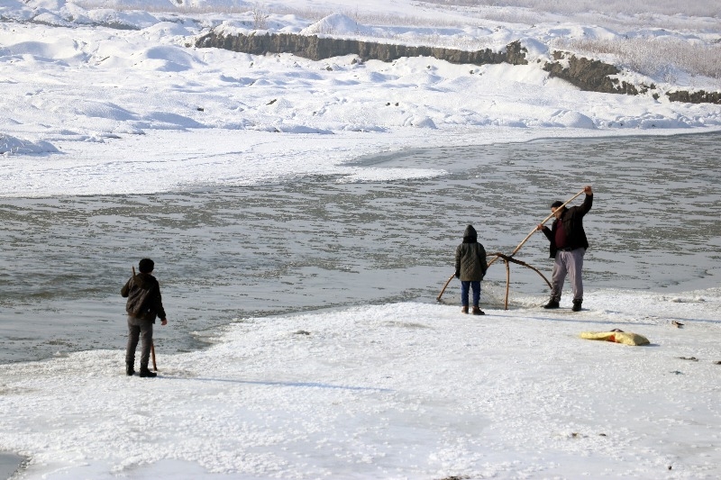 Ağrı’da dondurucu soğuğa rağmen nehirdeki buzları kırıp balık avlıyorlar